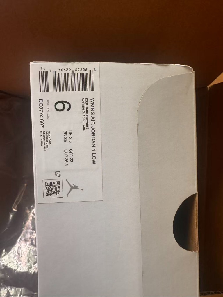 鞋盒侧面标签，印有 WMNS AIR JORDAN 1 LOW、货号 DC0774 607 和各体系尺码